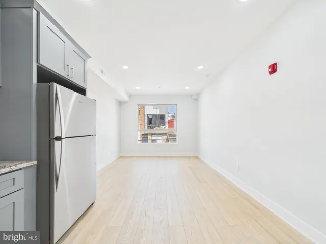 a view of kitchen with refrigerator and white walls