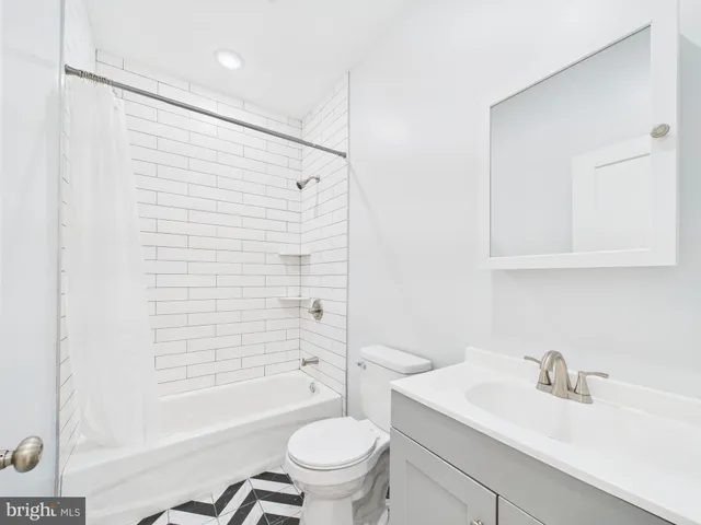 a bathroom with a sink toilet vanity and shower