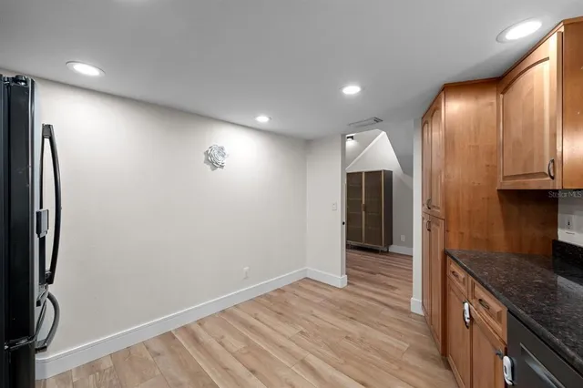 an empty room with wooden floor and a bathroom