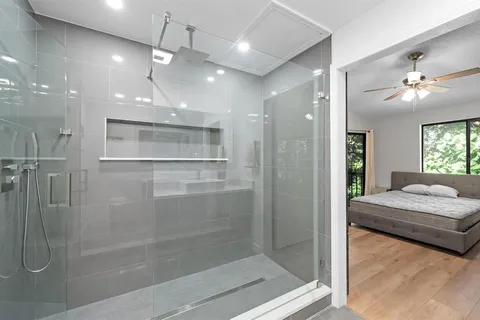 a bathroom with a granite countertop sink a mirror and shower