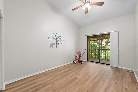 a view of a room with window a ceiling fan and wooden floor