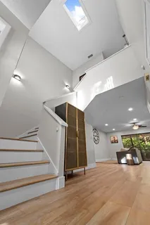a view of a hallway with stairs and wooden floor