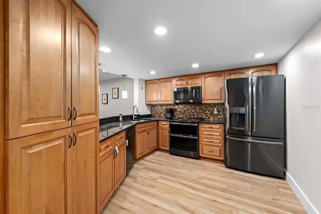 a kitchen with granite countertop stainless steel appliances and refrigerator