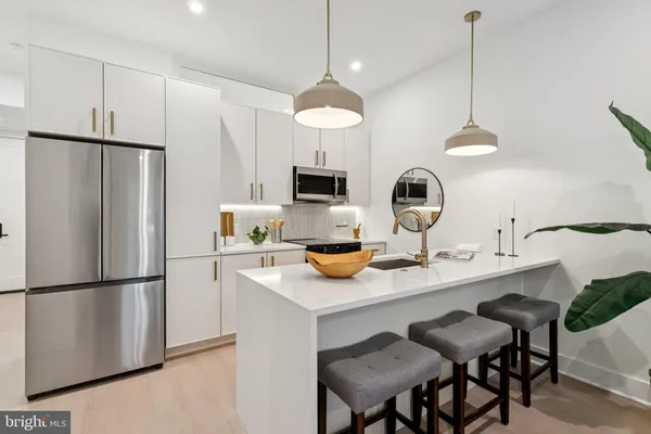a kitchen with stainless steel appliances granite countertop a sink a stove a refrigerator and island