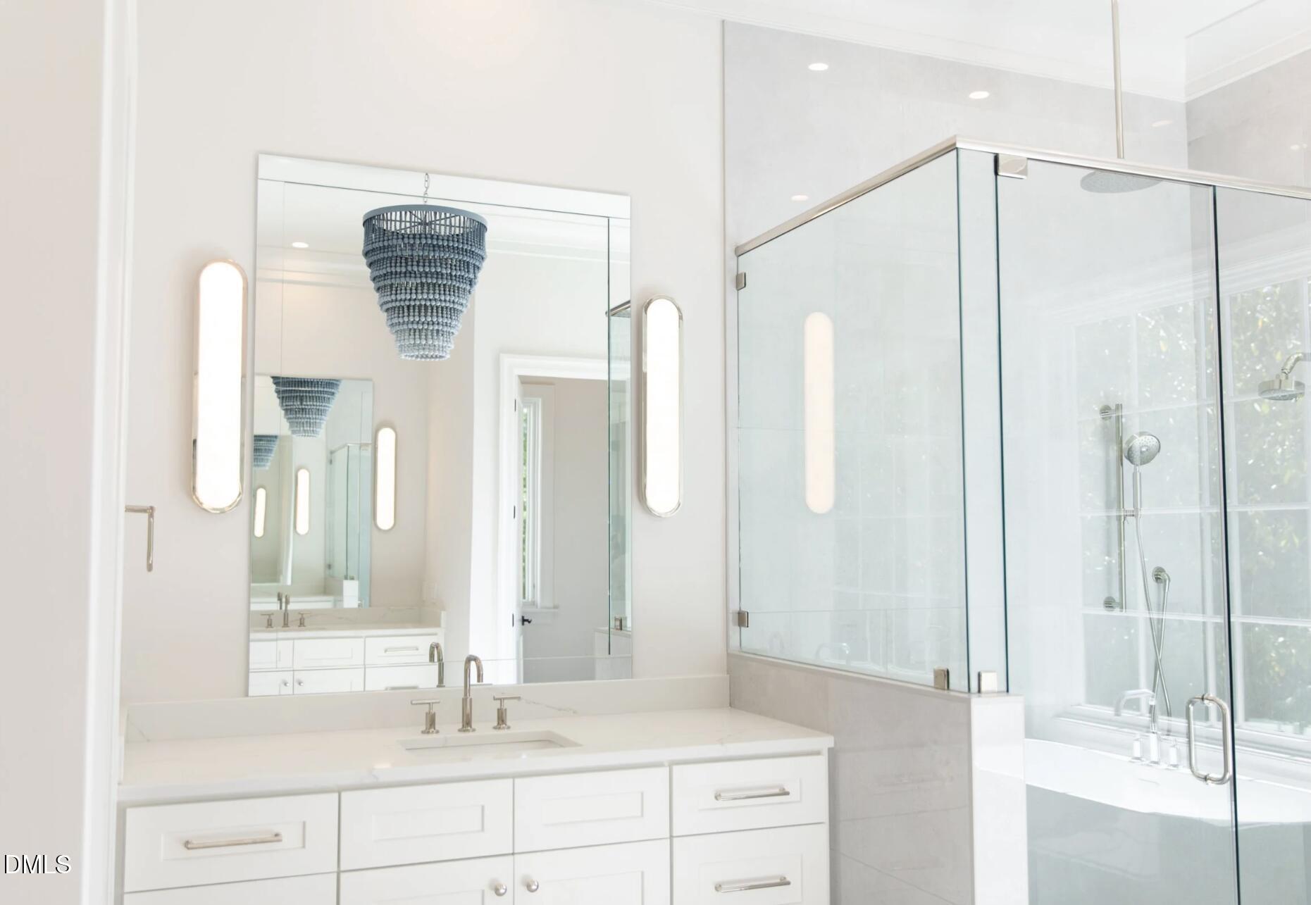 7425 Grist Mill Road Raleigh, NC 27615 - Photo 35 of 57 a bathroom with a shower sink and mirror