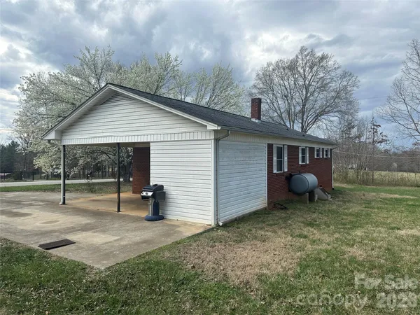 a view of a house with backyard and a tree