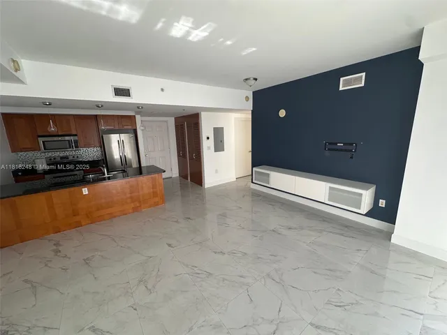 a view of a kitchen with a sink and a refrigerator