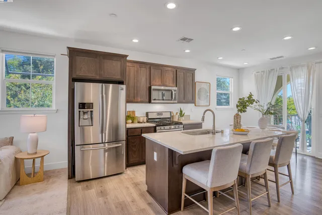 a kitchen with a refrigerator a stove a dining table and chairs