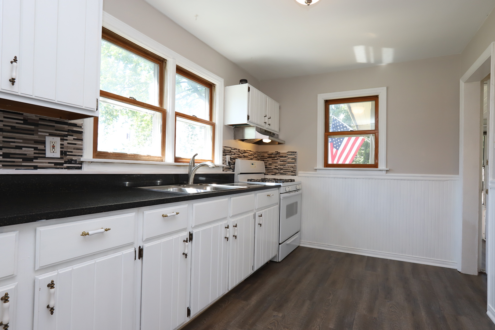 1103 Garfield Road Harvard, IL 60033 - Photo 2 of 28 a kitchen with granite countertop white cabinets and a window