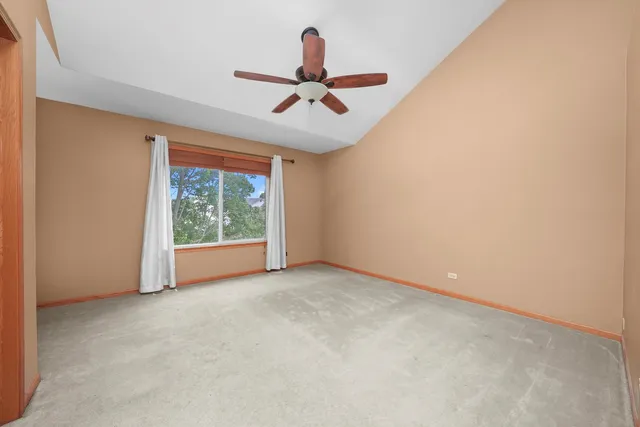 a view of an empty room with ceiling fan