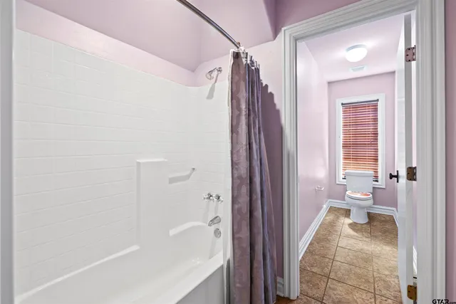a view of a hallway with wooden floor and windows