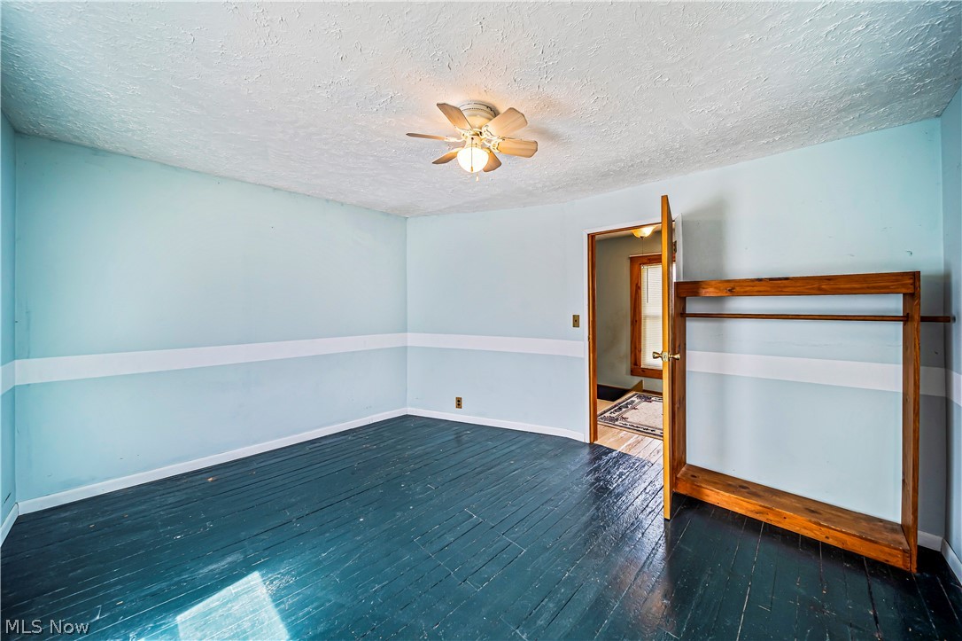116 South Cedar Street Geneva, OH 44041 - Photo 22 of 35 Bedroom with dark wood-type flooring, ceiling fan, and a textured ceiling