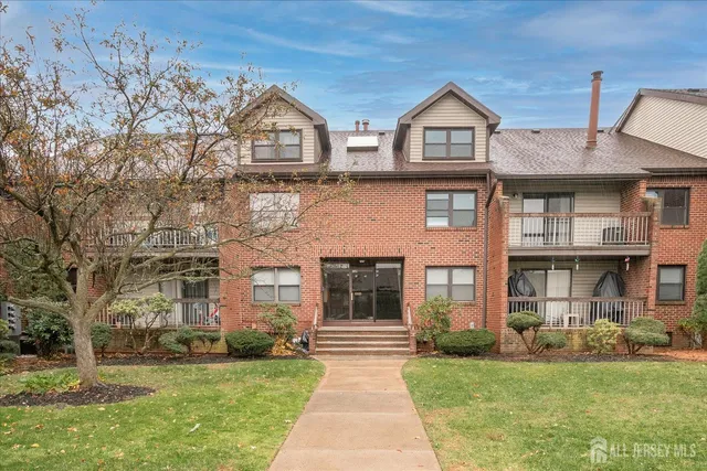front view of a brick house with a yard