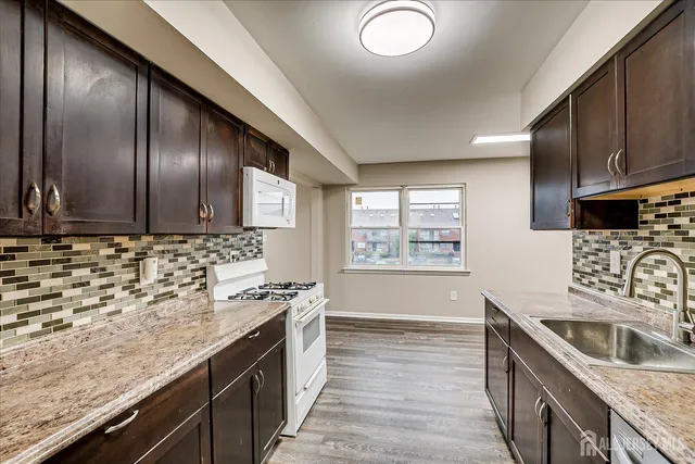 a kitchen with stainless steel appliances granite countertop a sink stove and cabinets