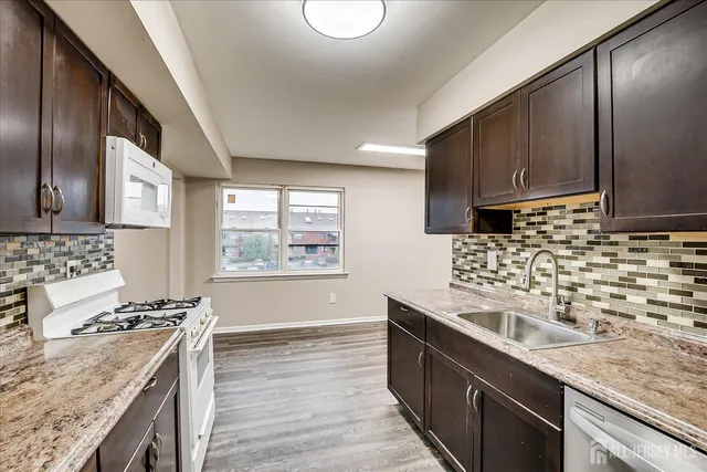 a kitchen with stainless steel appliances granite countertop a sink stove and cabinets
