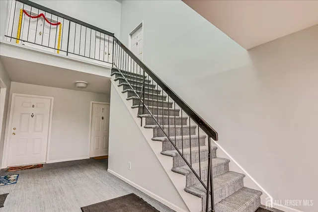 a view of staircase with railing and white walls