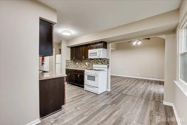 a kitchen with stainless steel appliances a stove top oven a sink and a refrigerator