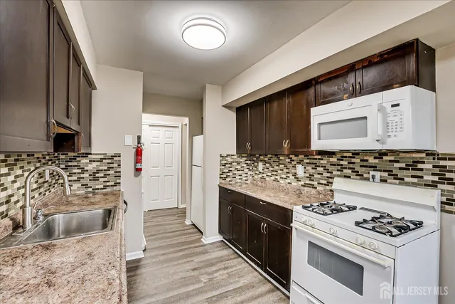 a kitchen with granite countertop a stove and a sink