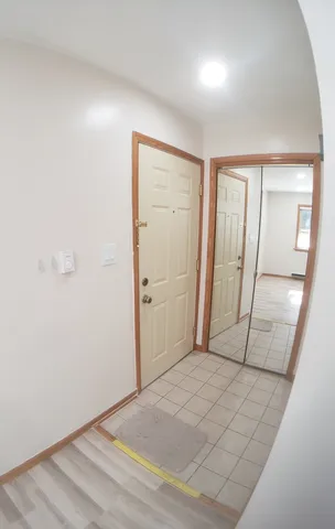 a view of a hallway with wooden floor and a bathroom