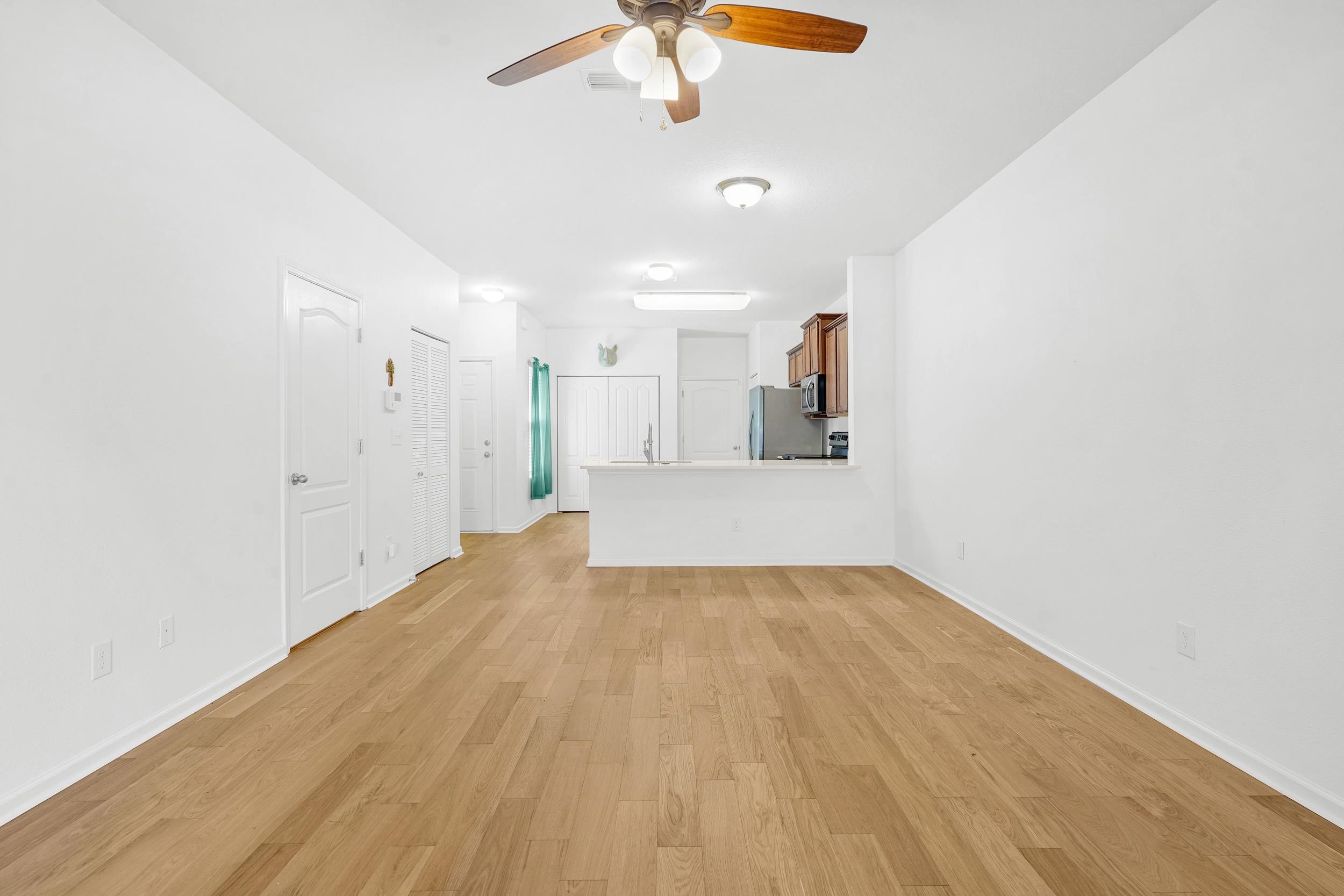 187 Whitland Way St. Augustine, FL 32086 - Photo 7 of 30 a view of a room with wooden floor and a ceiling fan