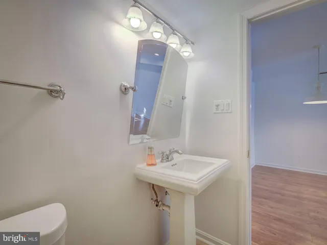 a bathroom with a sink a toilet and mirror