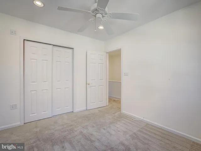 an empty room with fan and entryway