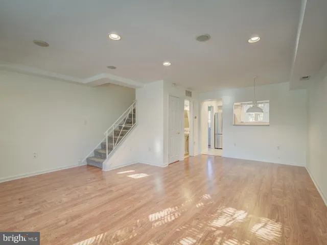 a view of an empty room with wooden floor and entryway