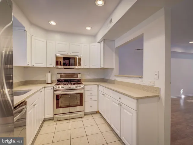 a kitchen with white cabinets appliances and sink