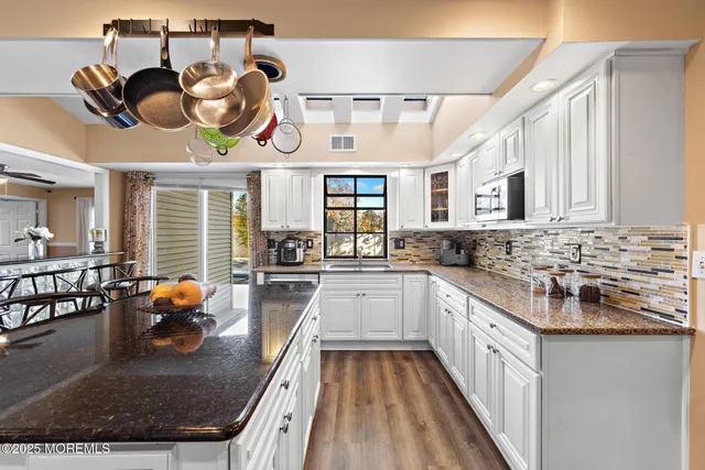 a kitchen with stainless steel appliances granite countertop a stove and cabinets