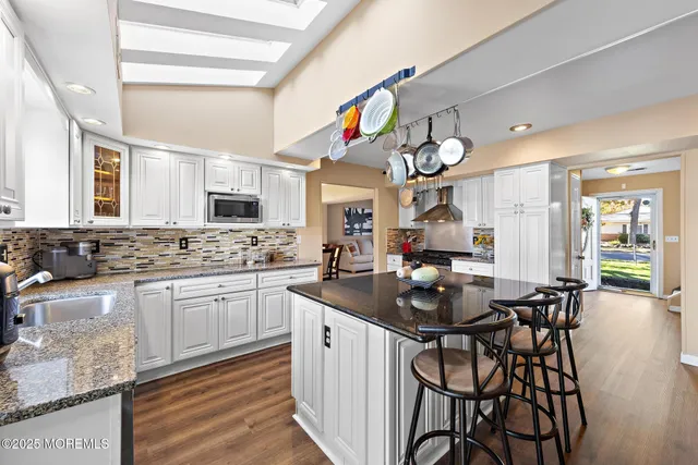 a kitchen with granite countertop a table chairs stove and cabinets