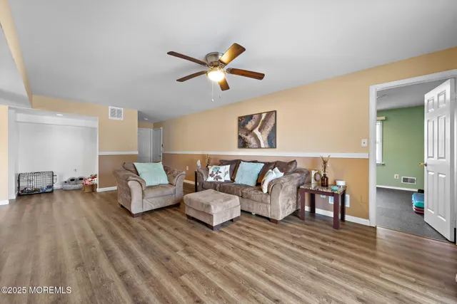 a living room with furniture and a wooden floor