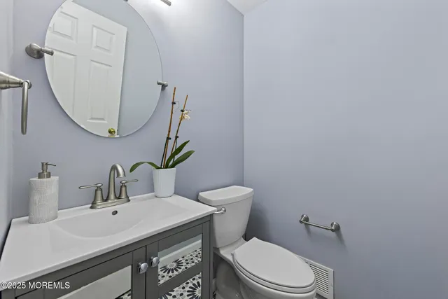 a bathroom with a toilet a sink and mirror