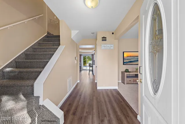 a view of entryway and hall with wooden floor