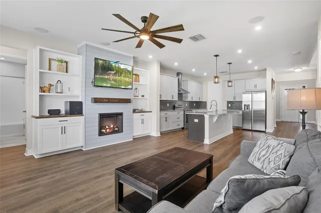 a view of a dining room and livingroom with furniture wooden floor a chandelier