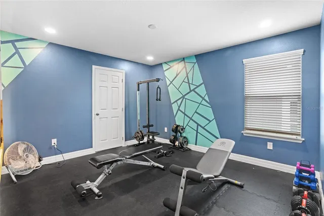 a view of an empty room and chandelier fan