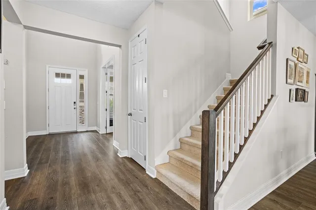 a kitchen with stainless steel appliances kitchen island granite countertop a stove a sink and white cabinets with wooden floor