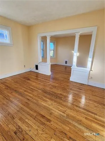 a view of empty room with wooden floor