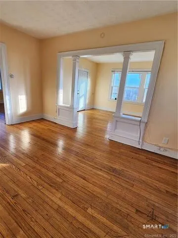 wooden floor in an empty room with a window