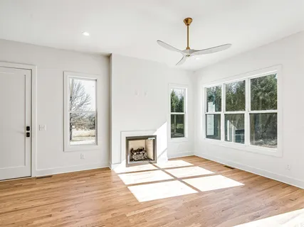 a view of an empty room with a window and fireplace
