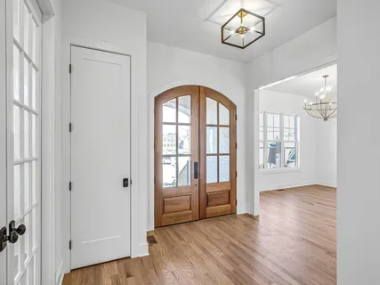 an empty room with wooden floor cabinet and windows