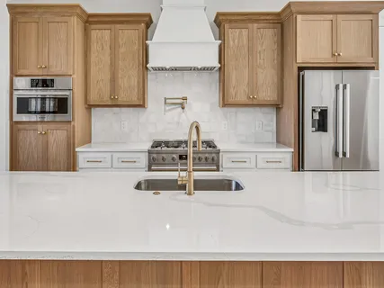 a kitchen with stainless steel appliances a refrigerator sink and cabinets