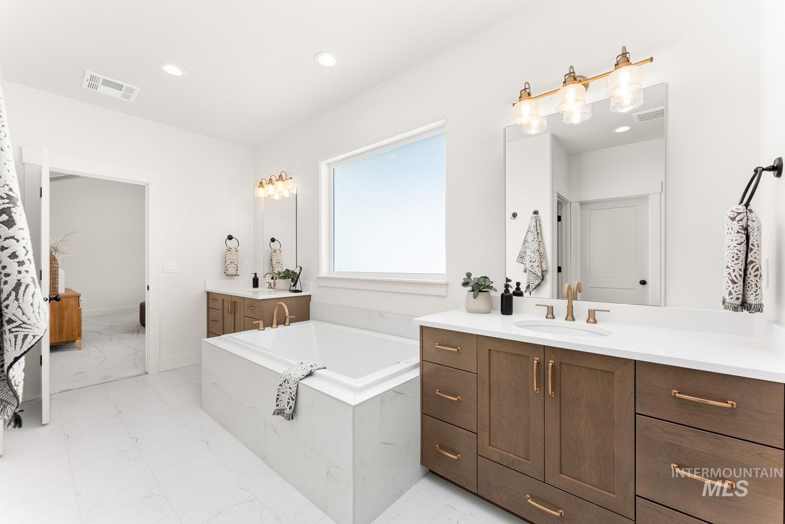 13344 North Spring Creek Way Boise, ID 83714 - Photo 17 of 39 Bathroom with two vanities, a bath, recessed lighting, and light marble finish flooring