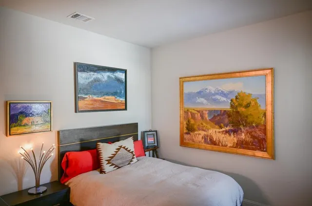 a bedroom with a bed and a painting on the wall