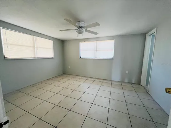 a view of empty room with open kitchen view