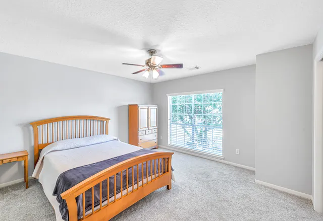 a bedroom with a bed and a large window