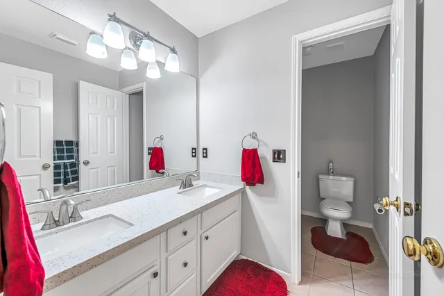 a bathroom with a sink vanity granite and toilet