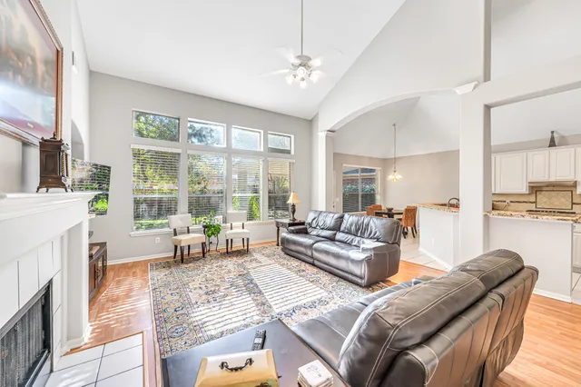 a living room with furniture and a large window with kitchen view