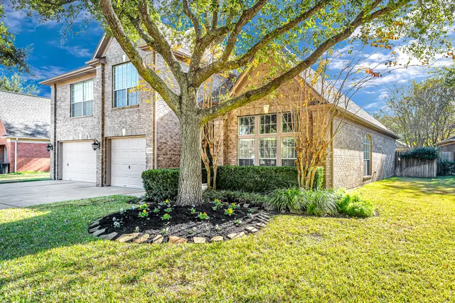 a front view of a house with a yard and trees