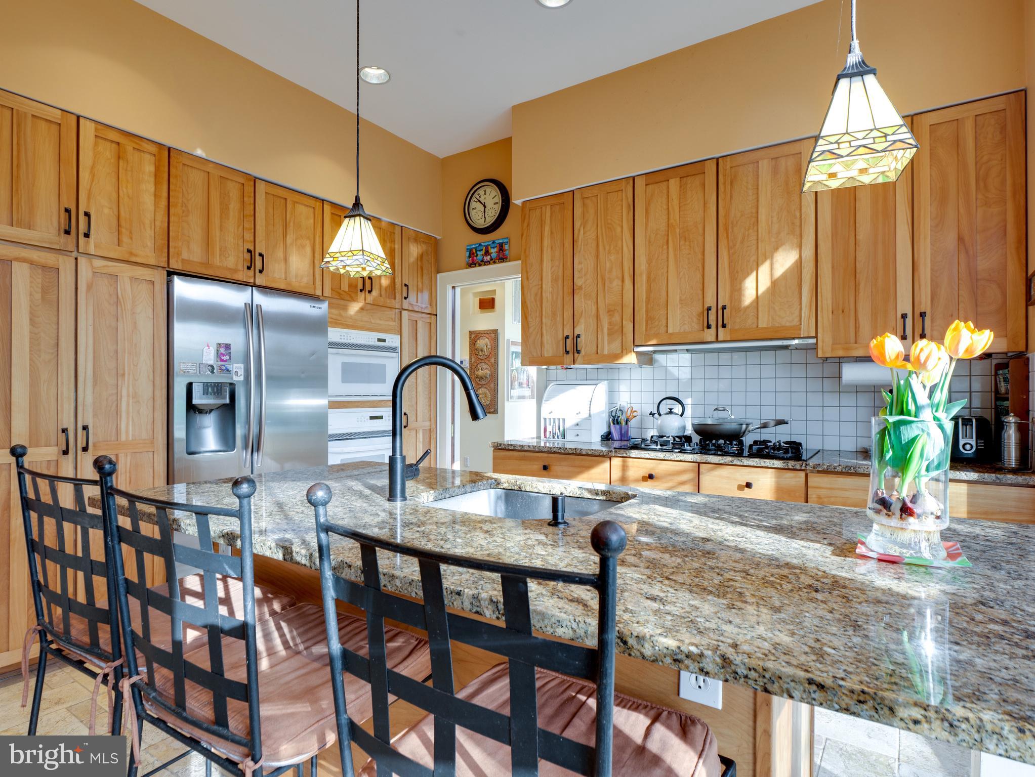 6306 Valley Road Bethesda, MD 20817 - Photo 24 of 74 a kitchen with granite countertop a table chairs stove and cabinets