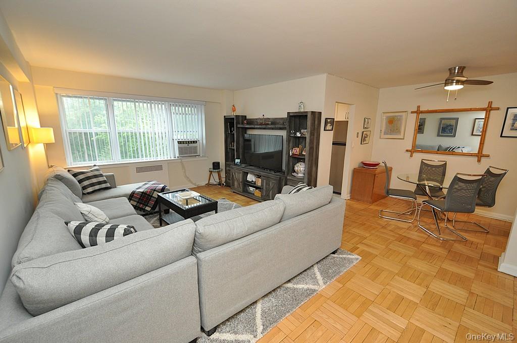 235 Garth Road, Unit A5B Scarsdale, NY 10583 - Photo 5 of 47 a living room with furniture window and a flat screen tv
